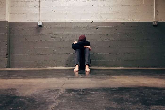 Depressed looking man against a wall